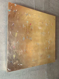 a gold piece of art hanging on a wall