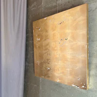 a gold piece of art hanging on a wall